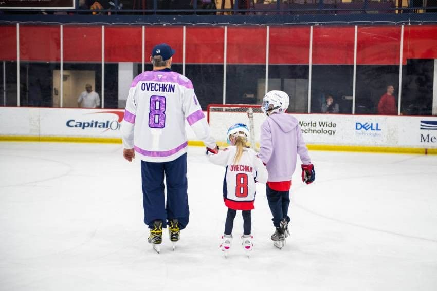Alex Ovechkin Washington Capitals NHL Player skating on the ice holding a little girls hand and her brother