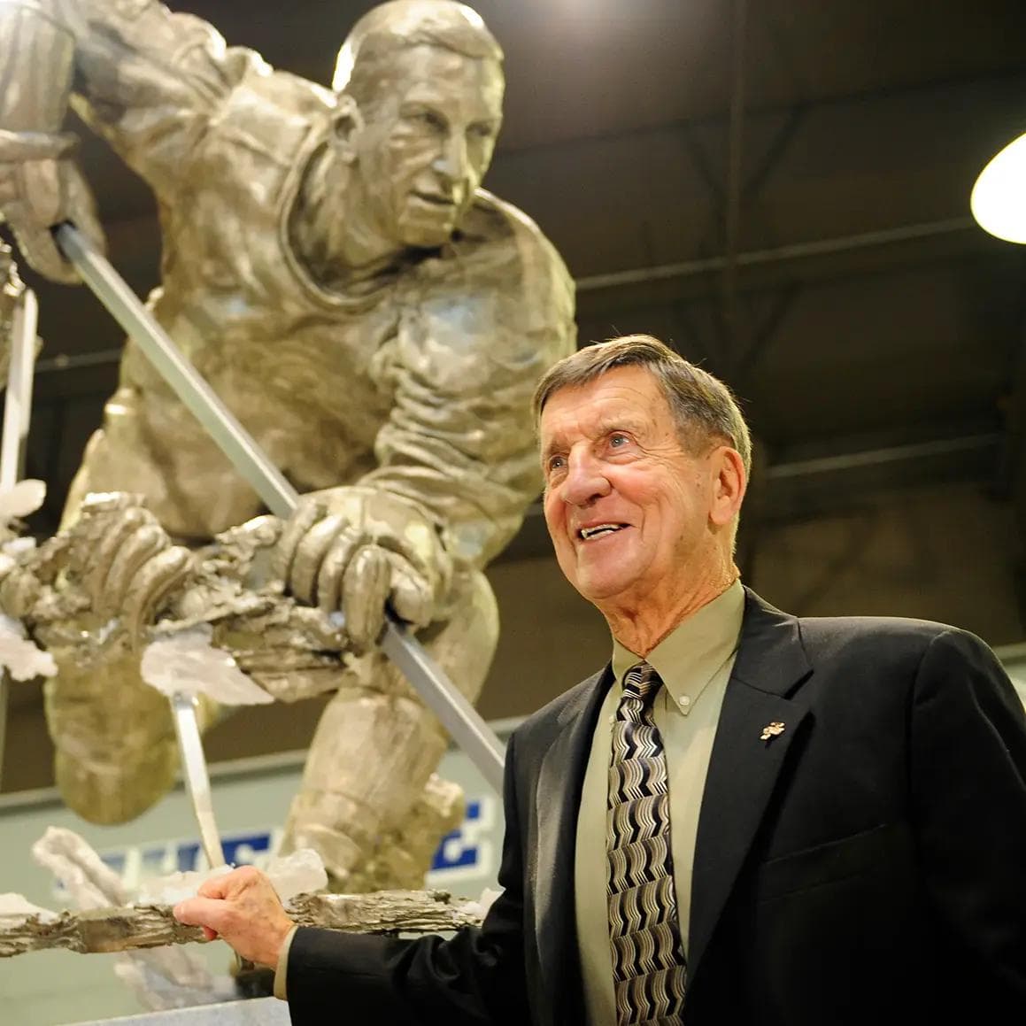 Ted Lindsay with statue during $1M HOPE Centre donation for autism support.
