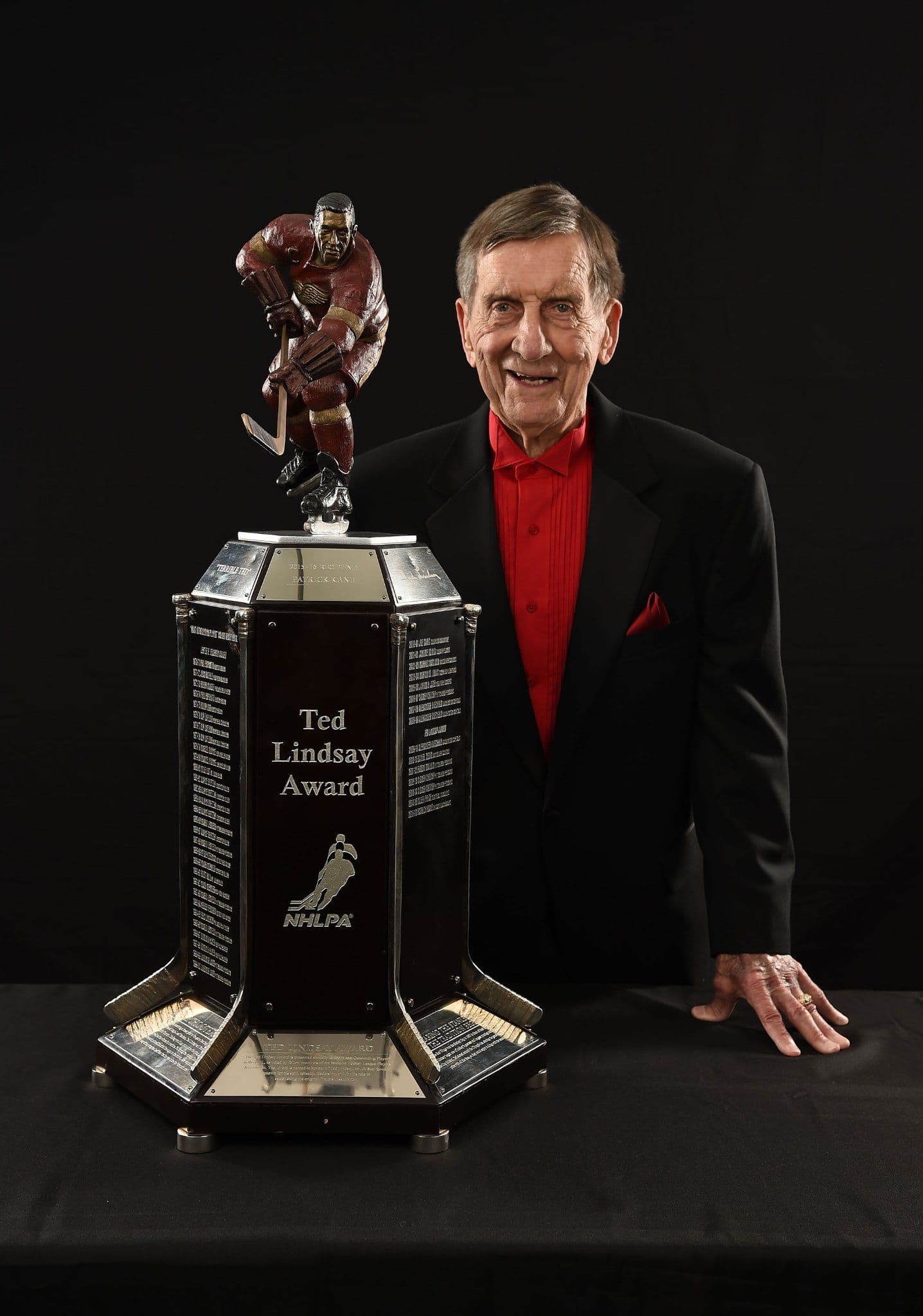 Ted Lindsay standing behind the Ted Lindsay Award Trophy